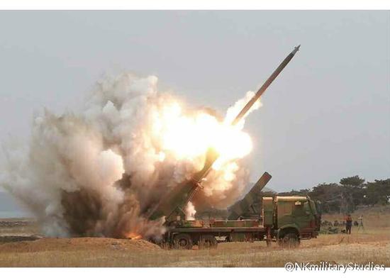朝鲜新型火箭炮试射照片，可能由于发射阵地构筑方式的原因，火箭尾焰被后方土堆阻挡，因此有巨大的烟尘从后方腾起 


