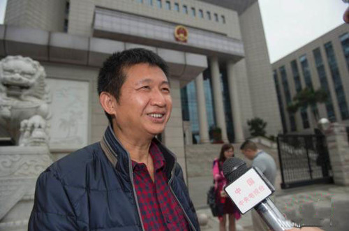 3月30日上午，海南省高级人民法院就陈满申请国家赔偿案举行公开听证。 图为陈满在海南省高级人民法院大门外接受媒体记者采访。中新社记者 骆云飞 摄