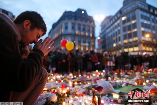 资料图：在布鲁塞尔古老的证券交易所外，当地民众为恐袭遇难者默哀。