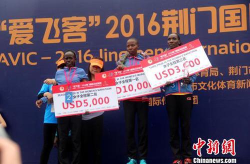 经过激烈竞争，全程马拉松男女组前三名为肯尼亚选手包揽。图为获得前三名的女选手　吴奇勇　摄