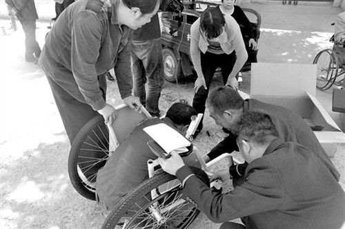　图为工作人员在三门峡灵宝市阳店镇东水头村为受助村民现场组装轮椅