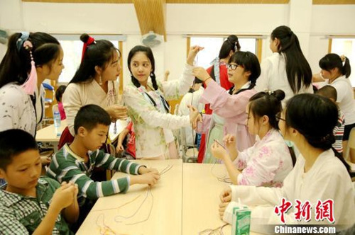 资料图：桂林汉服爱好者举办“端午雅集”活动，现场教学编织五彩绳。裴蕾 摄