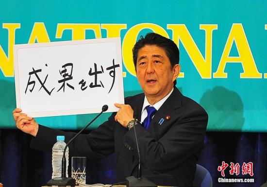 日本参议院选战在即，6月21日在日本记者俱乐部进行的选前党首辩论会上，“安倍经济学”的成败功过再度成为热辩之题。图为安倍现场高调亮出“搞出成果”字牌。<a target='_blank' href='http://www.chinanews.com/'>中新社</a>记者 王健 摄