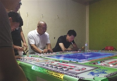 回龙观西大街一电玩城暗室内，几名玩家坐在赌博机前押分，这里的输赢远高于捕鱼机。