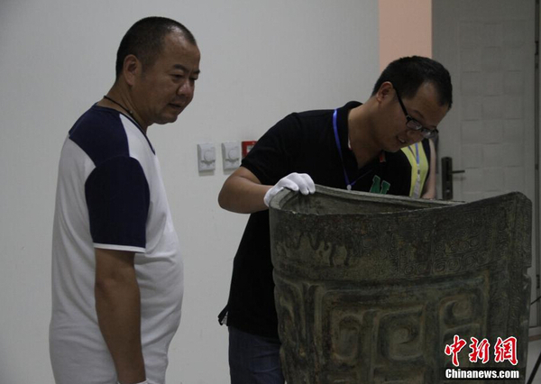 参展博物馆代表检查文物“象纹大铜铙”。 中新社记者 钟欣 摄