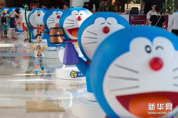 7月31日，一名小朋友被展出的哆啦A梦卡通造型所吸引。