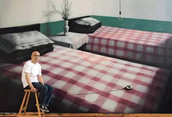 　　张晓刚在北京工作室，背后是他的作品《绿墙：两张单人床》（300x500cm, 2008）（图片来自Wmagazine）