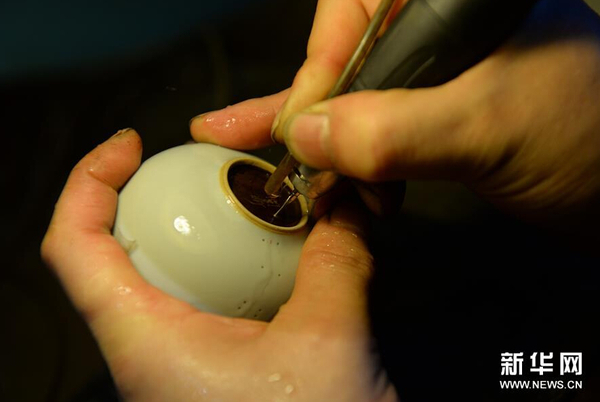 10月3日，曹庆励在工作室给瓷碗打孔。
