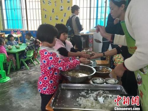 孩子们在领取营养午餐。　刘鹏 摄