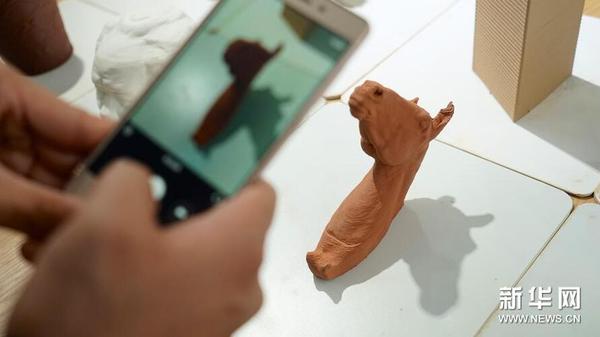 游客在拍摄一个“马头”形状的3D陶瓷打印作品（10月19日摄）。