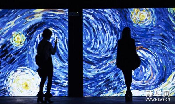 10月25日，在意大利罗马，两名女士观看梵高著名画作《星空》的多媒体效果展示。