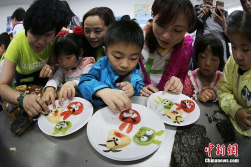 资料图。志愿者与南京留守儿童共同制作富有创意的水果拼盘。泱波 摄