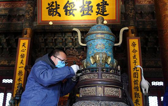 北京故宫太和殿，专家正在清理太和殿内青铜器上的灰尘。
