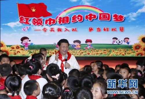 2014年5月30日上午，习近平来到北京市海淀区民族小学，参加庆祝“六一”国际儿童节活动。这是习近平在参加少先队入队仪式时，向少先队员们致以节日问候。新华社记者 鞠鹏 摄