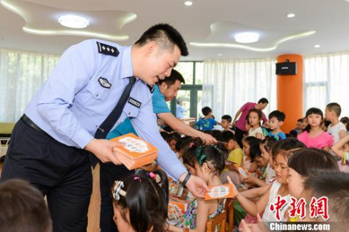 民警向小朋友发放反拐常识画册。陕西警方 供图