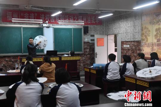 严磊在课堂上讲授如何进行油纸伞包顶，17名学生纷纷抬起头听讲。　吕明 摄