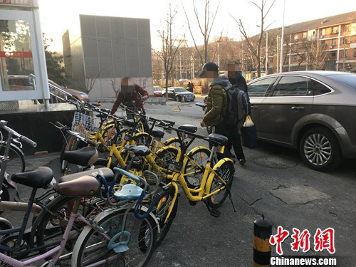 在北京街头的一处共享单车停车点，有小孩在尝试解锁。汤琪 摄