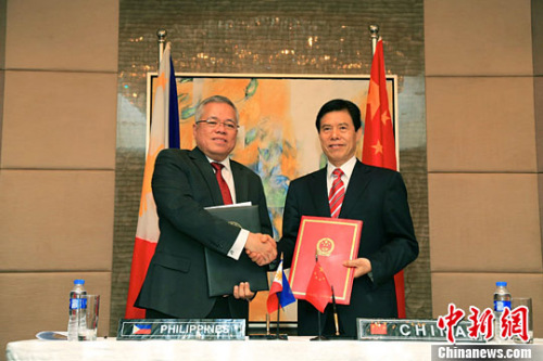 钟山（右）与洛佩兹（左）在会后签署会议纪要并出席新闻发布会。<a target='_blank' href='http://www.chinanews.com/'>中新社</a>记者 钟欣 摄