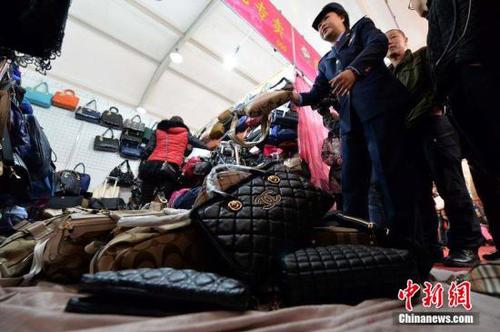 资料图 工商人员查出涉嫌出售假名牌包的摊位，将假货没收。 徐晓帆 摄 图片来源：CFP视觉中国