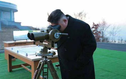 金正恩正在用望远镜观看火箭发射。