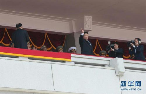 朝鲜最高领导人金正恩(前中)向参加群众游行的平壤市民挥手致意。新华社记者 朱龙川 摄 图片来源：新华网