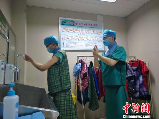 身穿30多斤重的铅衣的医务工作者，刚做完一台心脏介入手术，正在洗手，准备进行下一台手术。　崔涛　摄