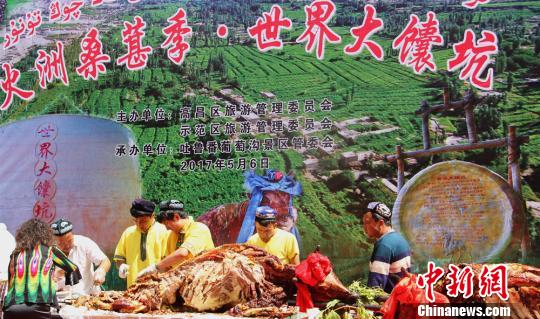 5月6日下午，吐鲁番高昌区举办“火洲桑葚季?世纪大馕坑”活动，烤全牛肉免费分享游客。　史玉江　摄