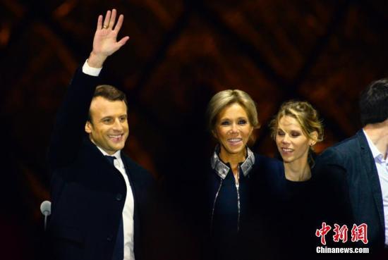 资料图：马克龙和妻子布丽吉特在巴黎卢浮宫前举行的庆祝胜选集会上。 中新社记者 龙剑武 摄