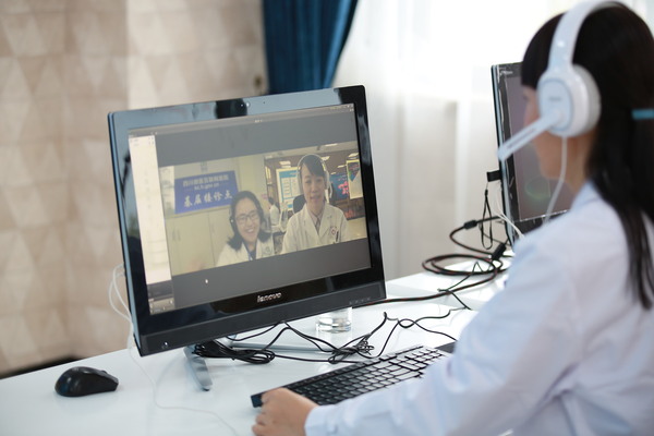 四川微医互联网医院医生正在与基层接诊点的医生交流患者病情。