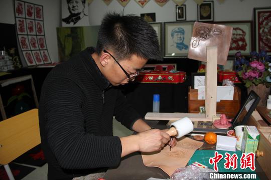图为魏康龙正在制作皮雕。　杨东东 摄