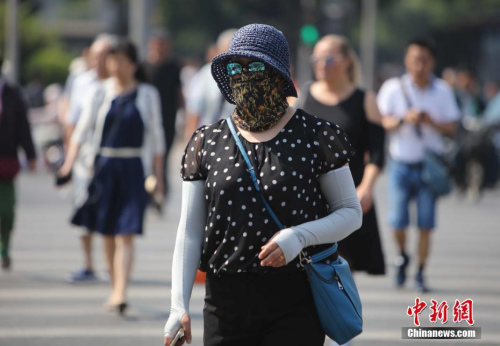 资料图：5月17日，北京街头的民众防晒出行。当日北京市气象台发布今年首个高温黄色预警。<a target='_blank' href='http://www.chinanews.com/'>中新社</a>记者 杨可佳 摄