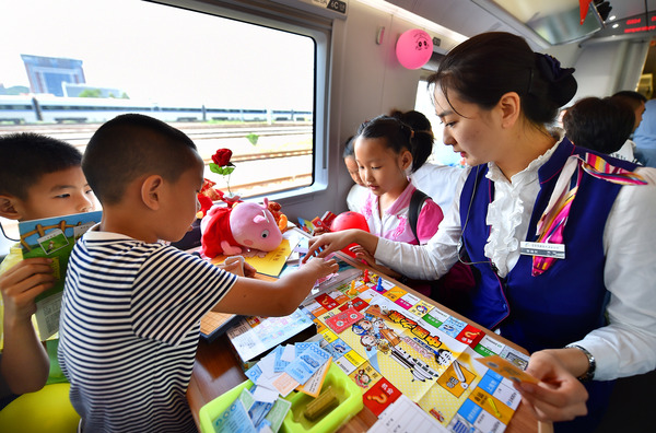 北京铁路局天津客运段值乘的厦门北至北京南G324次列车乘务员与儿童旅客互动做游戏。
