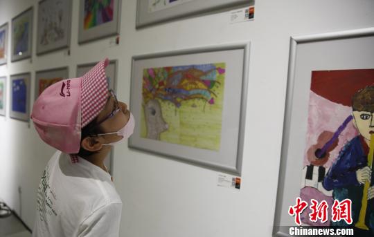 6月1日，第七届798艺术区国际儿童艺术周开幕。图为小观众参观在悦美术馆举办的“悦在童年”儿童艺术与公益联展。　张宇亮　摄
