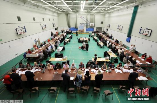 保守党领袖特雷莎·梅当天携丈夫菲利普回到她所属的选区伯克郡投票，工党领袖科尔宾在伦敦北部的伊斯灵顿投票。其他几大政党领导人也都回到各自所在选区投票。图为黑斯廷斯投票站，工作人员在清点票数。