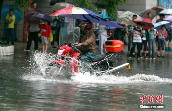 6月12日，贵阳市民骑摩托车在积水路段行驶。<a target='_blank' href='http://www.chinanews.com/'>中新社</a>记者 贺俊怡 摄