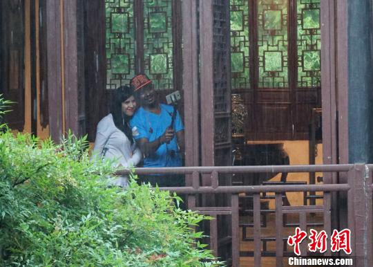 中国侨网雨中，到访无锡的外籍人士在寄畅园中玩起了自拍。　孙权　摄
