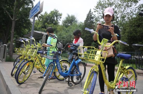 资料图 6月8日，民众在北京街头扫码租用一款“土豪金”色的共享单车。 <a target='_blank' href='http://www.chinanews.com/'>中新社</a>记者 杨可佳 摄