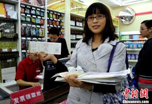 图为一位纳税人展示在超市刚领取的发票。<a target='_blank' href='http://www.chinanews.com/'>中新社</a>发 刘忠俊 摄