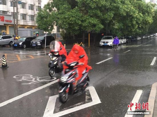 6月23日清晨，北京降雨持续，并出现了短时大雨。据北京市气象局官方微博消息，北京市气象台今日6时发布：今天白天小到中雨并伴有雷电，傍晚局地伴有短时大风或冰雹，北转东风2、3级，最高气温24℃；夜间有雷阵雨，东转北风2、3级，最低气温19℃。图为北京阜成路，市民雨中骑行。 <a target='_blank' href='http://www.chinanews.com/' >中新网</a>记者 富宇 摄