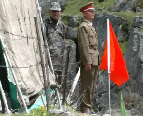 ▲资料图片： 2006年7月5日，在中印边境乃堆拉山口，一名中国边防军人（右）与一名印度边防军人隔着边界的铁丝网值勤。