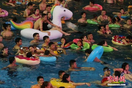资料图：7月8日晚，民众在冲浪池中戏水。 <a target='_blank' href='http://www.chinanews.com/'>中新社</a>记者 泱波 摄