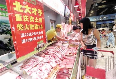 刚从大学毕业的销售员姜孔现场为顾客挑选猪肉。 重庆晨报记者 苑铁力摄