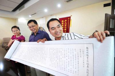 2008年8月28日，曹媛（左一）向本报赠送“扬州晚报书法版奥运报道”长卷（资料图片）
