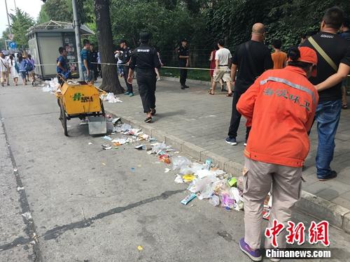 近日，清华大学门外游客爆满，排队人群滞留垃圾遍地。汤琪 摄
