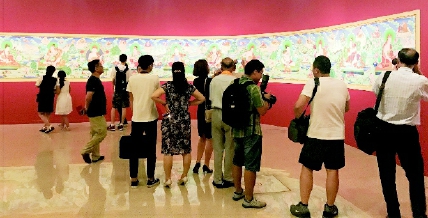 观众们正在欣赏两代唐卡画师合作的30米长卷。