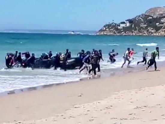 视频截图：8月9日，一船非法移民乘坐皮艇抵达西班牙南部一处海滩。（新华/美联）