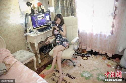 图为27岁的刘洋在自己的卧室里做直播，她2015年开始，从一名就职于化工企业的工科女摇身一变成为职业主播，月收入也是此前工作的五倍之多。 游思行 摄 图片来源：视觉中国