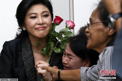当地时间2017年8月1日，泰国前总理英拉抵达法院，做大米收购案结案辩护陈词，支持者送上玫瑰花。