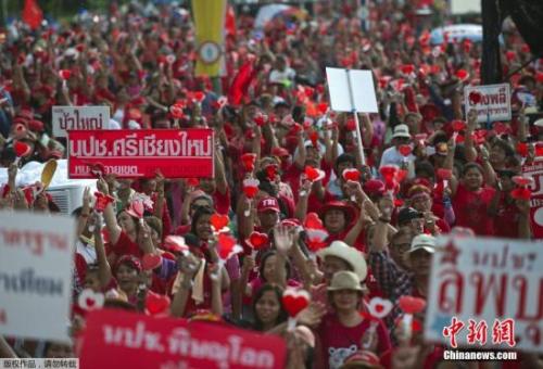 资料图： 当地时间2014年5月11日，泰国曼谷，泰国“红衫军”高举英拉和他信的头像举行大规模集会，声援政府并抗议宪法法院等独立机构的“不公”。