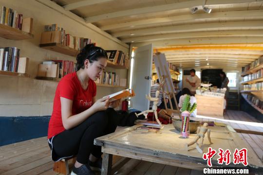 9月5日，海南三亚西岛渔村，游客在“海上书房”翻看书籍。　尹海明 摄